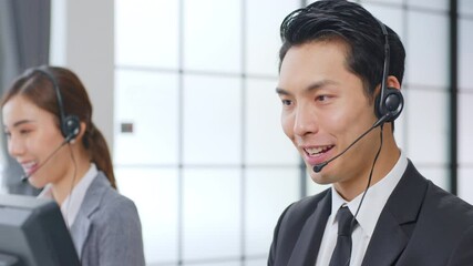 Asian call center team / customer service / telesales in formal suit wearing headset or headphone talking with customer in modern office