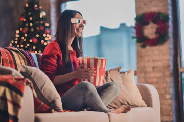 Fototapeta na wymiar Photo of young smiling cheerful happy good mood woman sit sofa eat popcorn watch 3-D movie in 3d glasses at home house