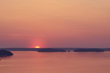Sunset over the sea. Sun is touching horizon.