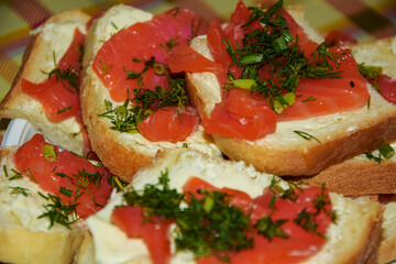 Close-up of a sandwich with salted red fish fillets. Macro photo of delicious red fish sandwich. Smoked salmon sandwich appetizer with toasted