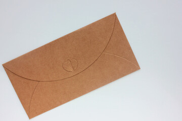 Craft envelope with heart on white background. Top view, copy space