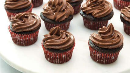 Chocolate cupcakes with chocolate buttercream frosting close up on white background
