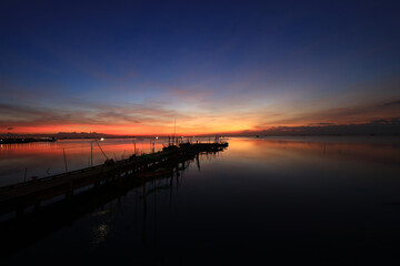 Fototapeta na wymiar Fishing port or local port againt twiligh sky during sunset or sunrist at Chonburi, Thailand, Dramatic sunset sky