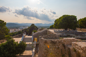 Denia castle ruins, medieval architecture. Moorish castle on a rocky crag overlooking the city of Dénia. Alicante province, Costa Blanca, Valencian community, Spain.