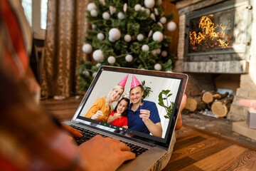 Naklejka na ściany i meble Caucasian woman at christmas, having video chat with friends and family using laptop. social distancing during covid 19 pandemic at christmas time.