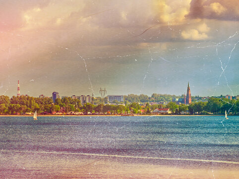 Made to look analog and vintage (colors, crackles) postcard with a landcape of a Pogoria III Lake with a Dabrowa Gornicza city in the distance. With clouds over it.