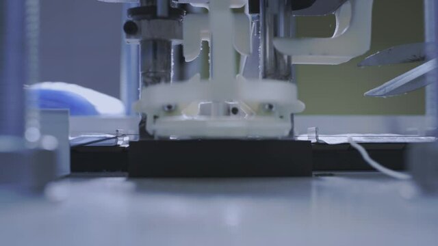 Production of medical protective face masks for air filtration. Coronavirus protection machine, covid-19. Press presses the fixing thread for ear loops or ties. Macro production line, conveyor.