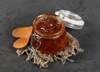 Marmalade berry, jam from sea buckthorn in a glass jar on a linen napkin dark background in rustic style