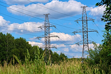 Obraz premium A long line of electrical transmission towers carrying high voltage lines.