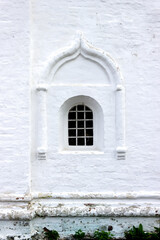 A small window in the thick fortress wall of an ancient monastery