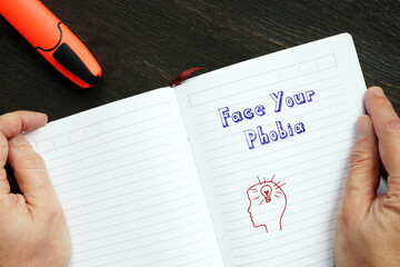 Motivational concept about Face Your Phobia with sign on the piece of paper.