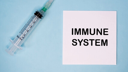 'Immune system' message on sticker with syringe near. Medical concept.