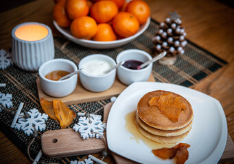 Festive table setting with vegane pancakes and tangerines