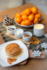 Festive table setting with vegane pancakes and tangerines