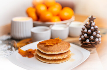 Festive table setting with vegane pancakes and tangerines