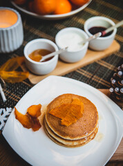 Festive table setting with vegane pancakes and tangerines