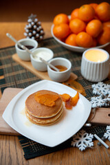 Festive table setting with vegane pancakes and tangerines