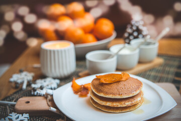 Obraz na płótnie Canvas Festive table setting with vegane pancakes and tangerines