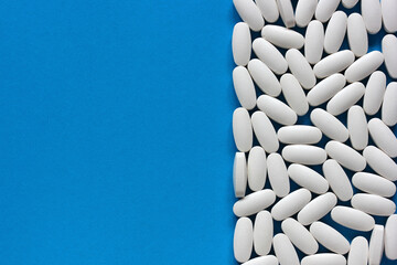 white tablets on a blue background, top view.