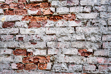 Old red brick masonry with traces of destroyed plaster.