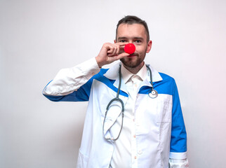 Young doctor with a clown nose. Portrait.