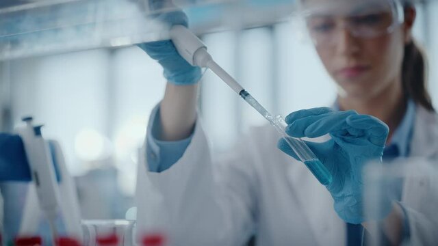 Medical Research Laboratory: Portrait of a Beautiful Female Scientist Using Micro Pipette for Analysis. Advanced Scientific Lab for Medicine, Biotechnology, Microbiology Development. Hands Close-up