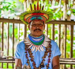 Ecuador. A Shaman from the Siona Community in his traditional costume stands model for a photo....