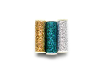 Sewing threads on a white background. Bright shiny threads. Gold and white color. Trending colors