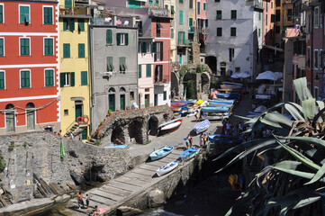 Fototapeta na wymiar View of Cinque Terre Village with plants, buildings, sea boats and people