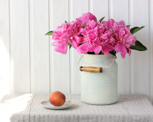 peonies in a can and a peach on a light background.