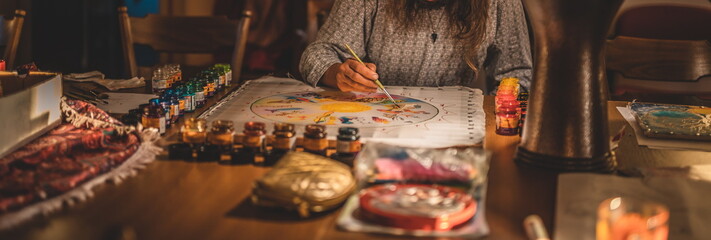 Man paints a beautiful picture on silk.