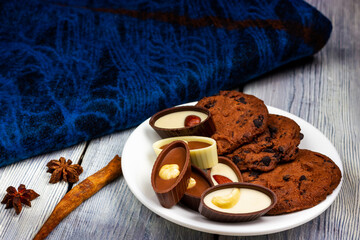 Chocolates with almonds and hazelnuts on a light wooden table with a blue shawl in the background. Provence style