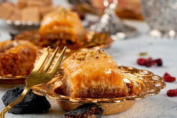 Piece of Turkish baklava in golden arabic plate