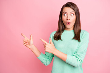 Photo of amazed lady shocked look indicate fingers empty space wear teal sweater isolated pink color background