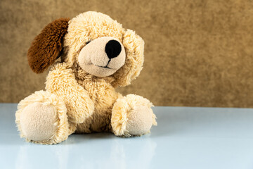 Sad teddy bear on a blue table.