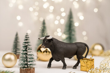 Decorative bull symbol of New Year on the background of Christmas tree and bokeh