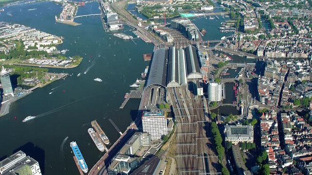 Aerial view of the IJ and the Amsterdam Centraal Station in Netherlands. Many ferries and cargo ships. Netherlands. 