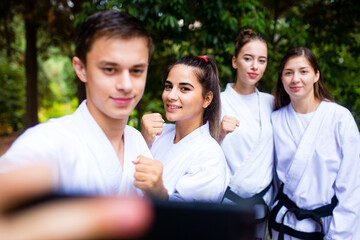 people high kicks during training of taekwondo outdoors bamboo background