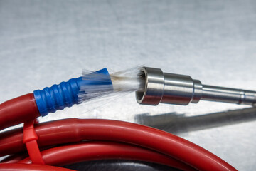 broken red fiber optic cable lies on a silver base