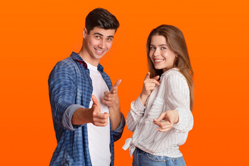 Funny lucky millennial man and woman point fingers at camera and rejoice to success after win at...
