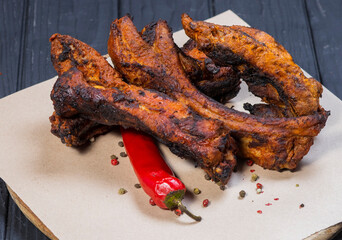Fried ribs with pepper a on black wooden background