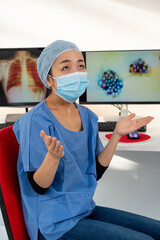 Fototapeta na wymiar Une femme médecin asiatique devant une image médicale du covid-19.
