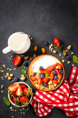 Fototapeta na wymiar Yogurt granola with fresh berries on black stone table. Top view with copy space. Healthy food, snack or breakfast.