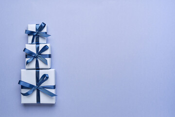 Stack of tree gift boxes on blue background. Top view, flat lay