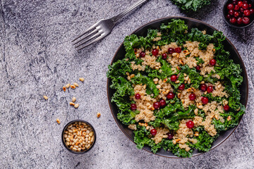 Healthy raw kale and quinoa salad with cranberry and pine nut.