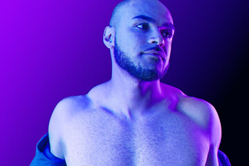Young black man takes off the shirt in neon light