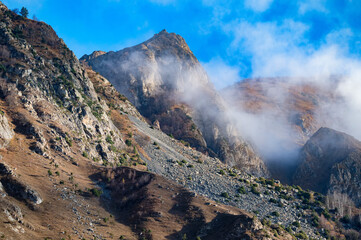 Rocks and clouds in North Caucasus mountains in autumn on sunny day