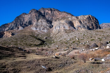 Rocks and dry grass in North Caucasus mountains in autumn on sunny day