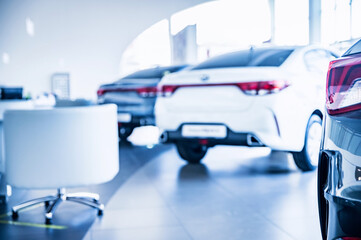 New shiny cars at dealer showroom blurred background