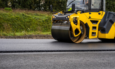 Asphalt road roller with heavy vibration roller compactor press new hot asphalt on the roadway on a...